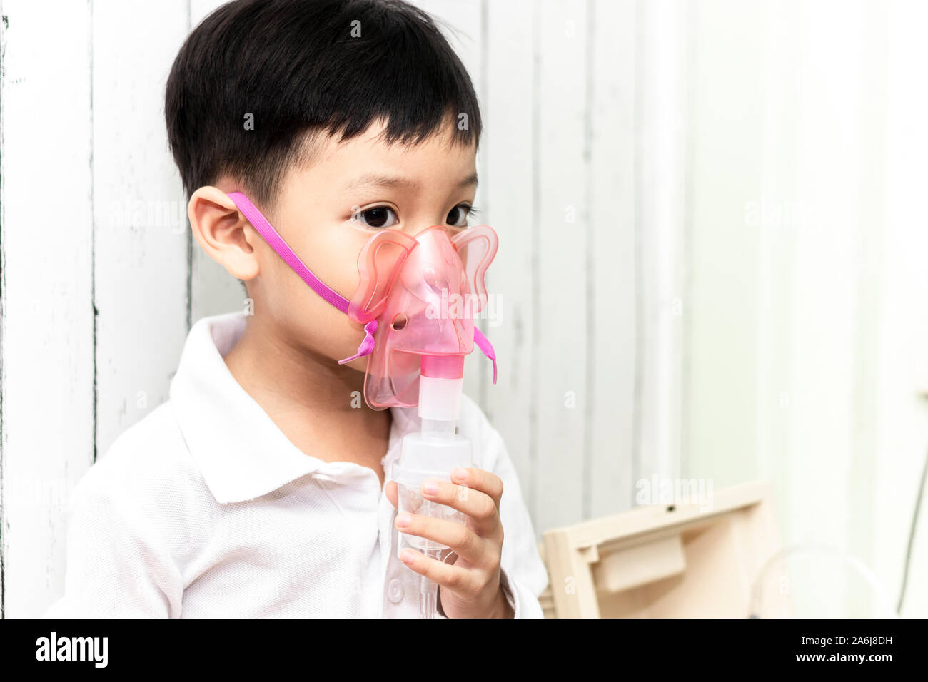 Asia boy using nebulizer and inhaler for the treatment. Little child