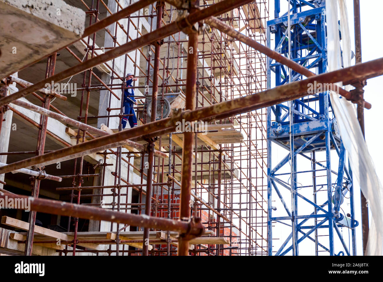 Scaffold with wooden platform is placed against edifice, building under ...