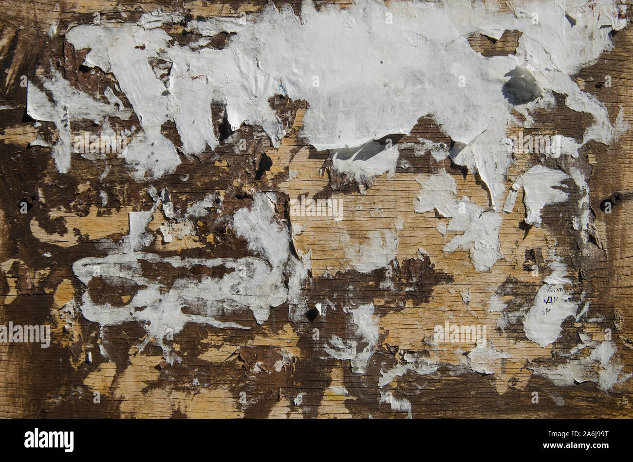 Empty public bulletin board with scraps of old advertisement posters