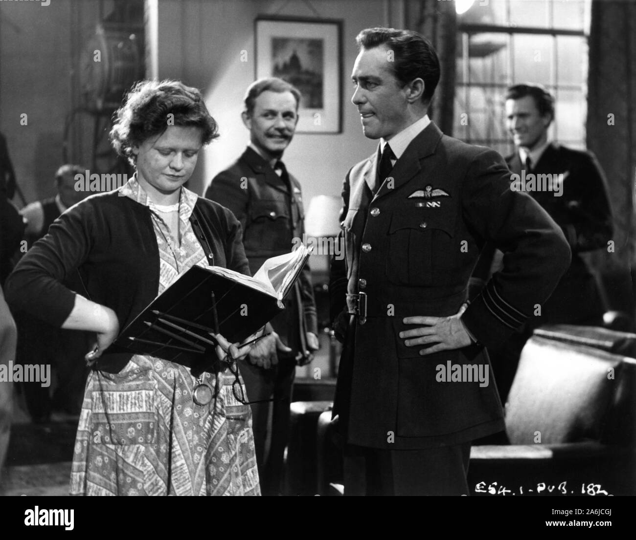 RICHARD TODD as Wing Commander Guy Gibson and BILL KERR as Flight Lieutenant H.B.Martin on set candid with script / continuity girl (possibly Thelma Orr) filming THE DAM BUSTERS 1955 director Michael Anderson books Paul Brickhill and Guy Gibson screenplay R.C. Sherriff Associated British Picture Corporation Stock Photo