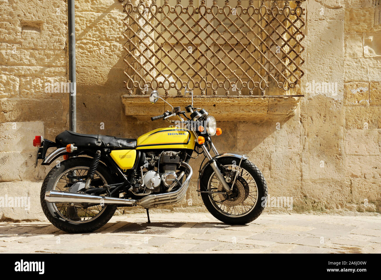 Yellow Honda 400 motorcycle standing in the street of old italian town.  Lecce, Apulia, Italy Stock Photo - Alamy
