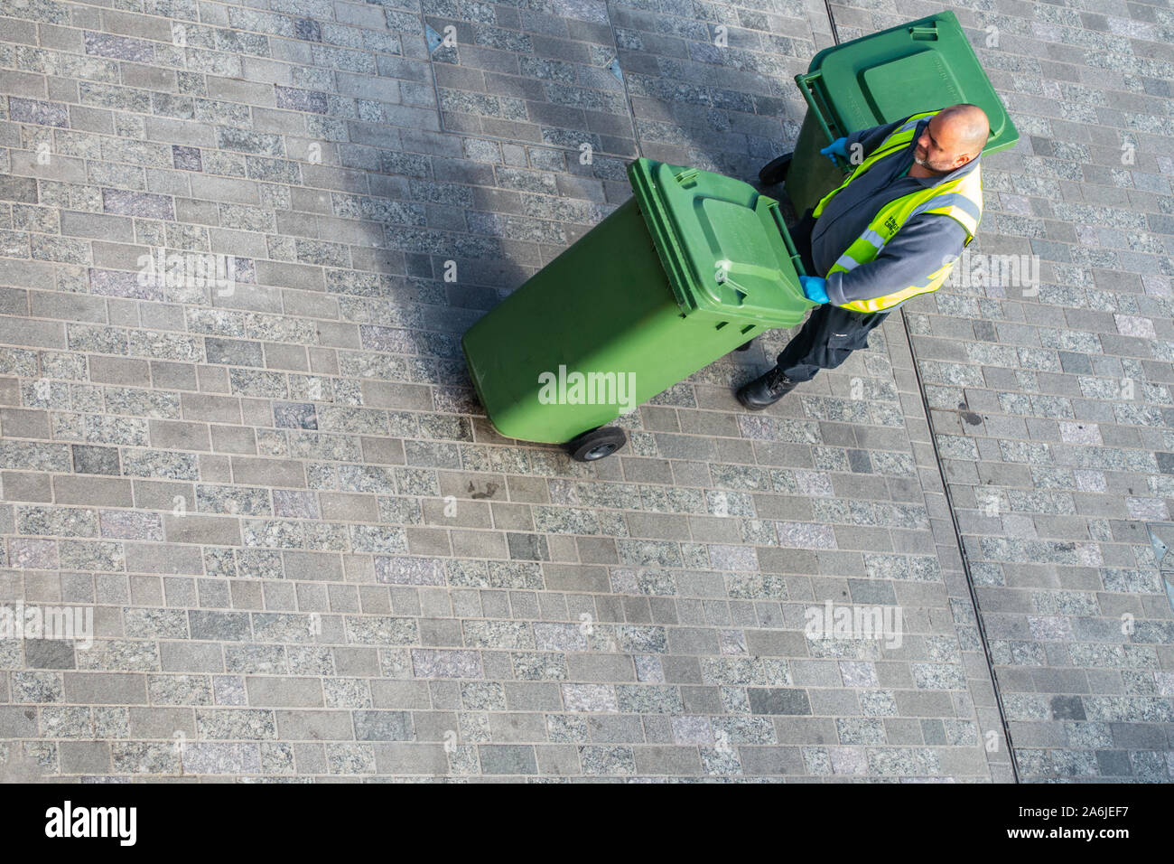 cleaner collecting rubbish bins from above Stock Photo