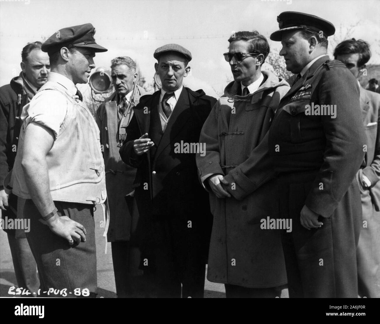 RICHARD TODD as Wing Commander Guy Gibson with Director MICHAEL ANDERSON (in sunglasses) and Technical Advisor Group Captain / Air Commodore J.N.H. WHITWORTH on set location candid filming THE DAM BUSTERS 1955 books Paul Brickhill and Guy Gibson screenplay R.C. Sherriff Associated British Picture Corporation Stock Photo