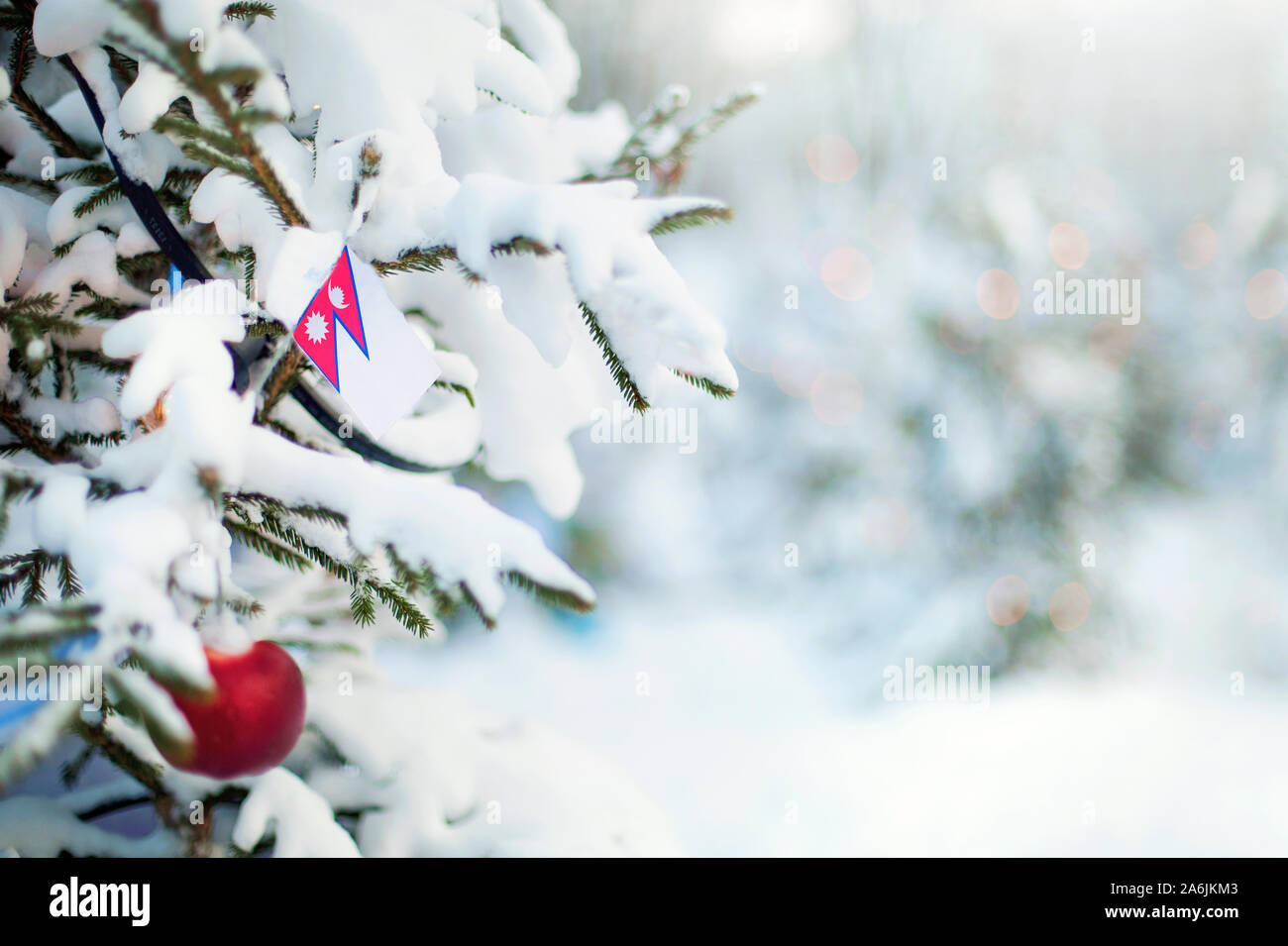 Christmas Nepal. Xmas tree covered with snow, decorations and a flag