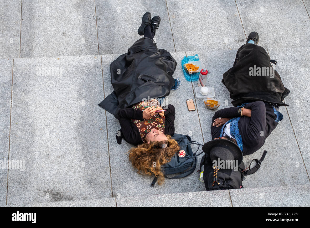 Birds eye view of a trendy couple relax on city steps Stock Photo