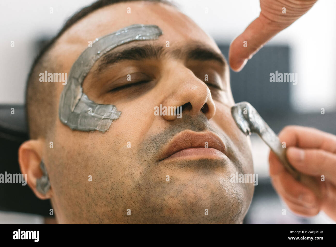Male face waxing. Barber removes hair by shugaring from face of turkish