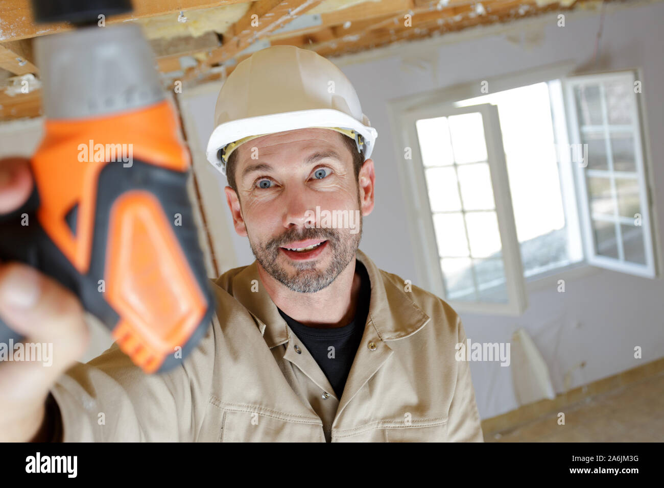 portrait of a worker drilling ceiling Stock Photo