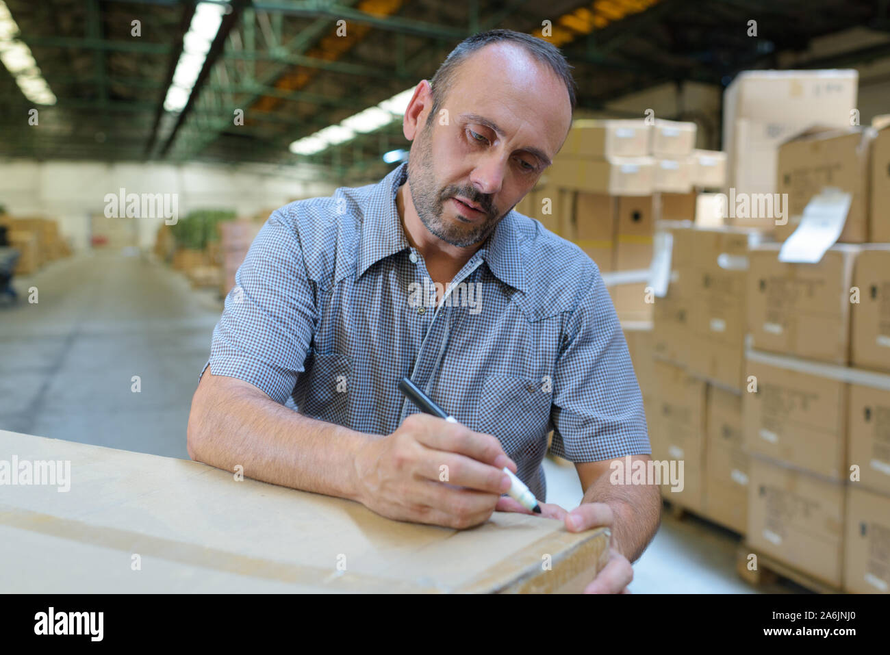 delivery man hold box in warehouse Stock Photo