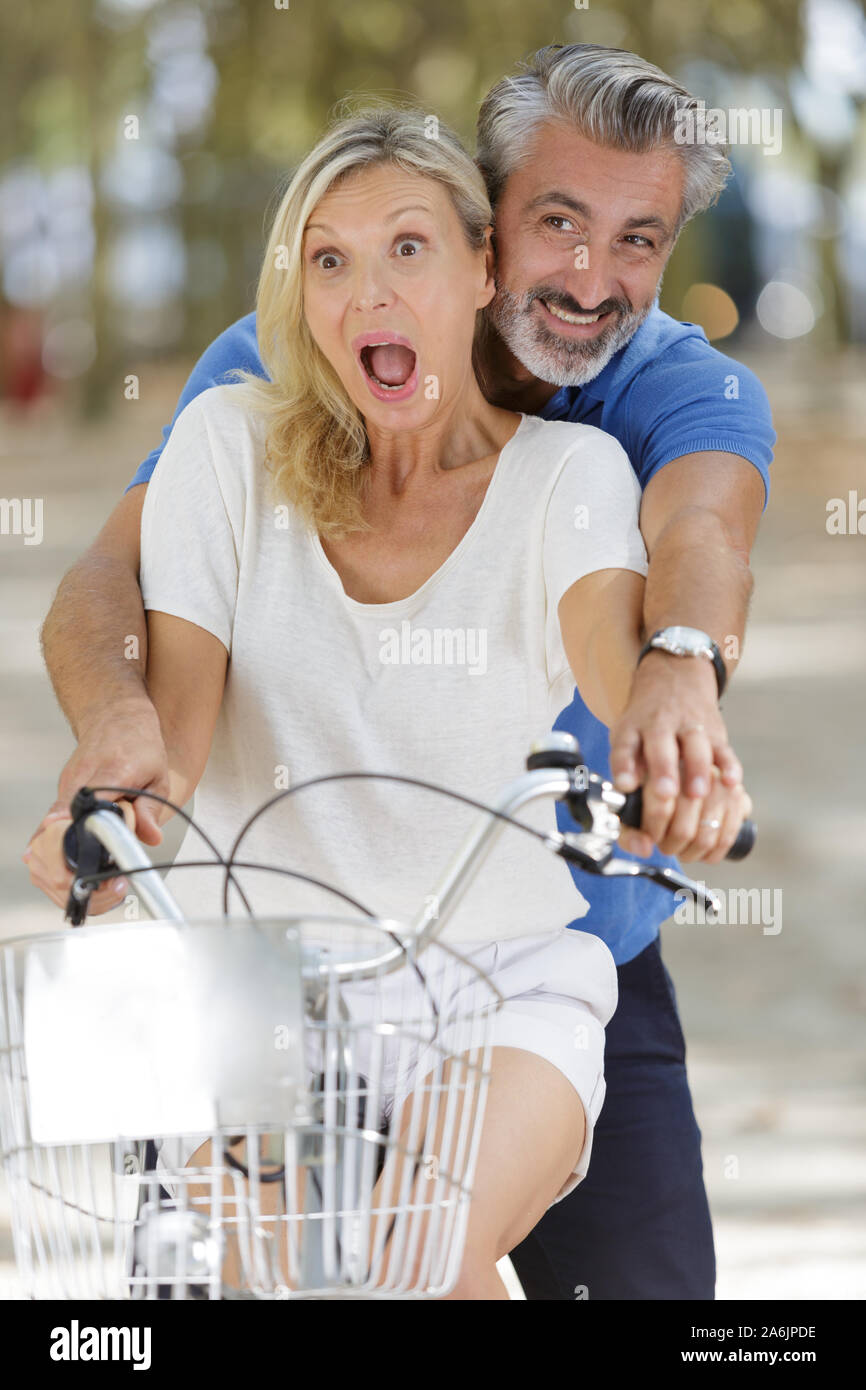 happy mature couple having fun on a bicycle Stock Photo