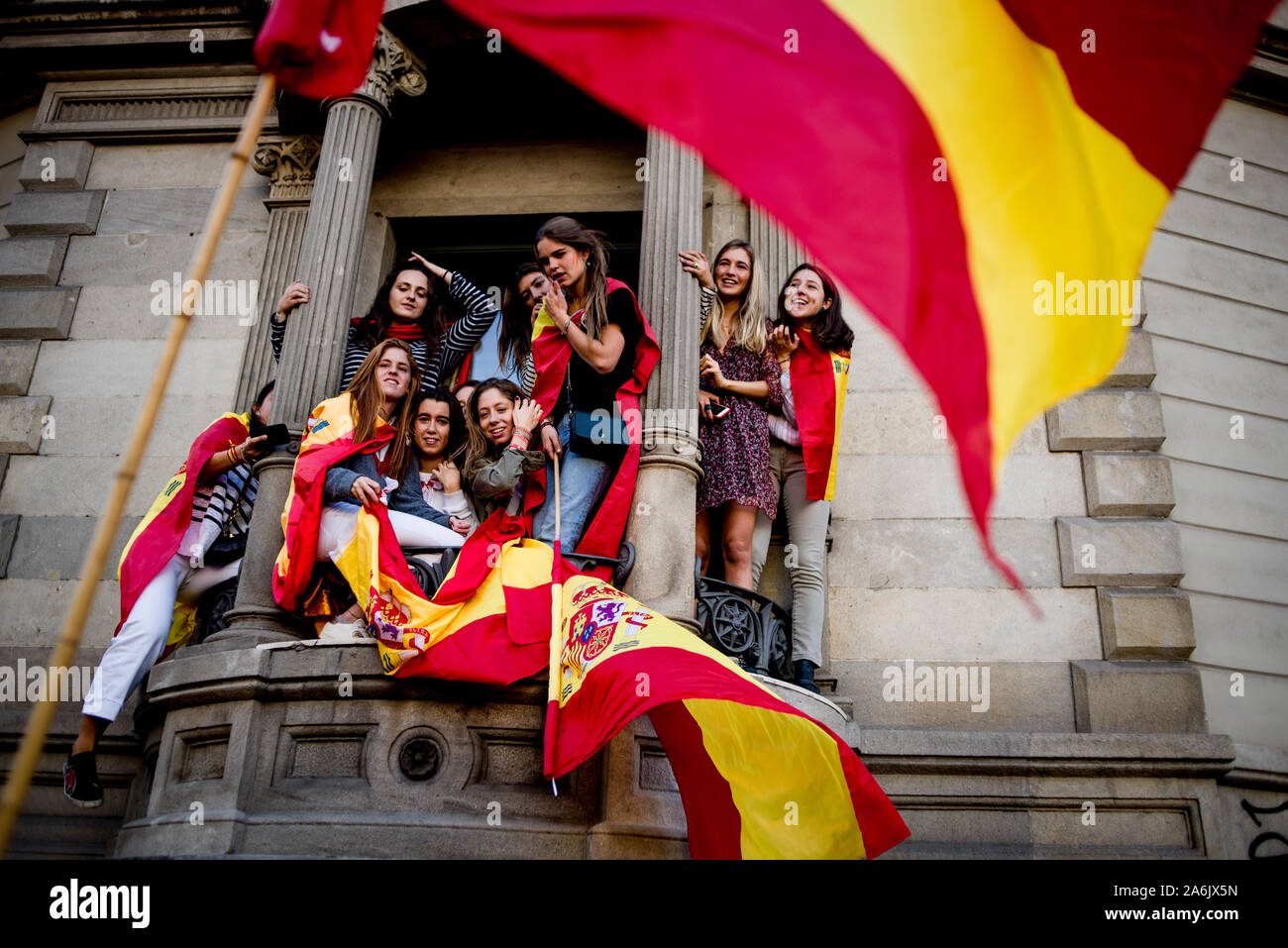 Barcelona, Spain. 27th Oct, 2019. A group of girls are on a balcony with Spanish flags during a unionist march in Barcelona. Thousands pro-unionist demonstrators marched  in Barcelona against Catalan independence during a protest called by Societat Civil Catalana organization. Credit:  Jordi Boixareu/Alamy Live News Stock Photo