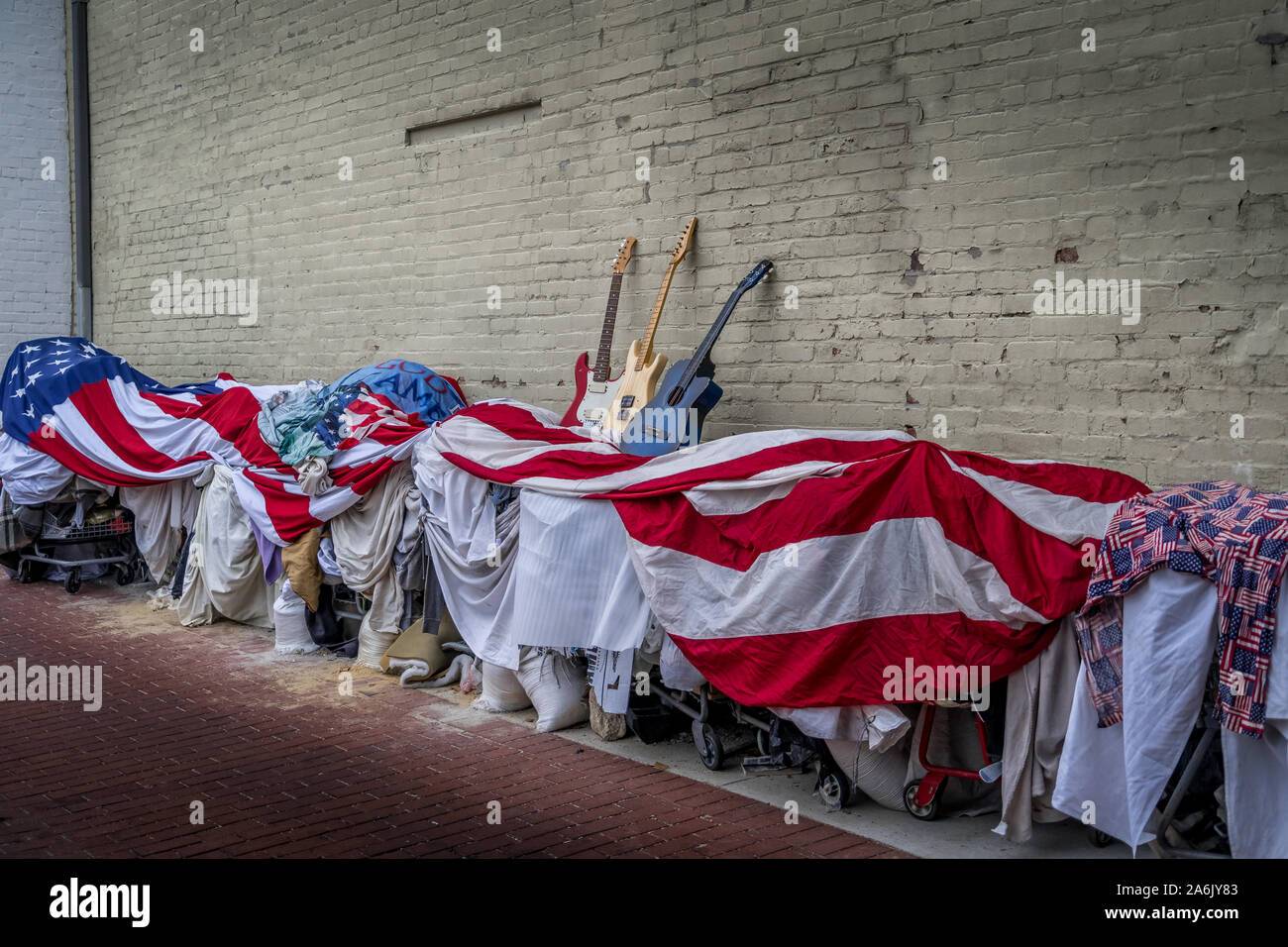 Homeless people carts belongings covered with a giant American flag with blue white and red guitars on top in Washington DC Stock Photo