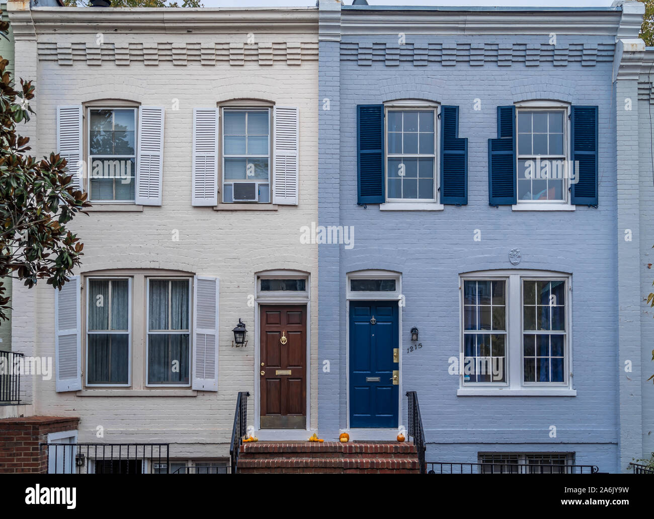 Real Estate: upscale, luxury historic  townhouse facade colonial Georgian style symmetric double pan windows dark shutters, yellow, gray, blue, painte Stock Photo