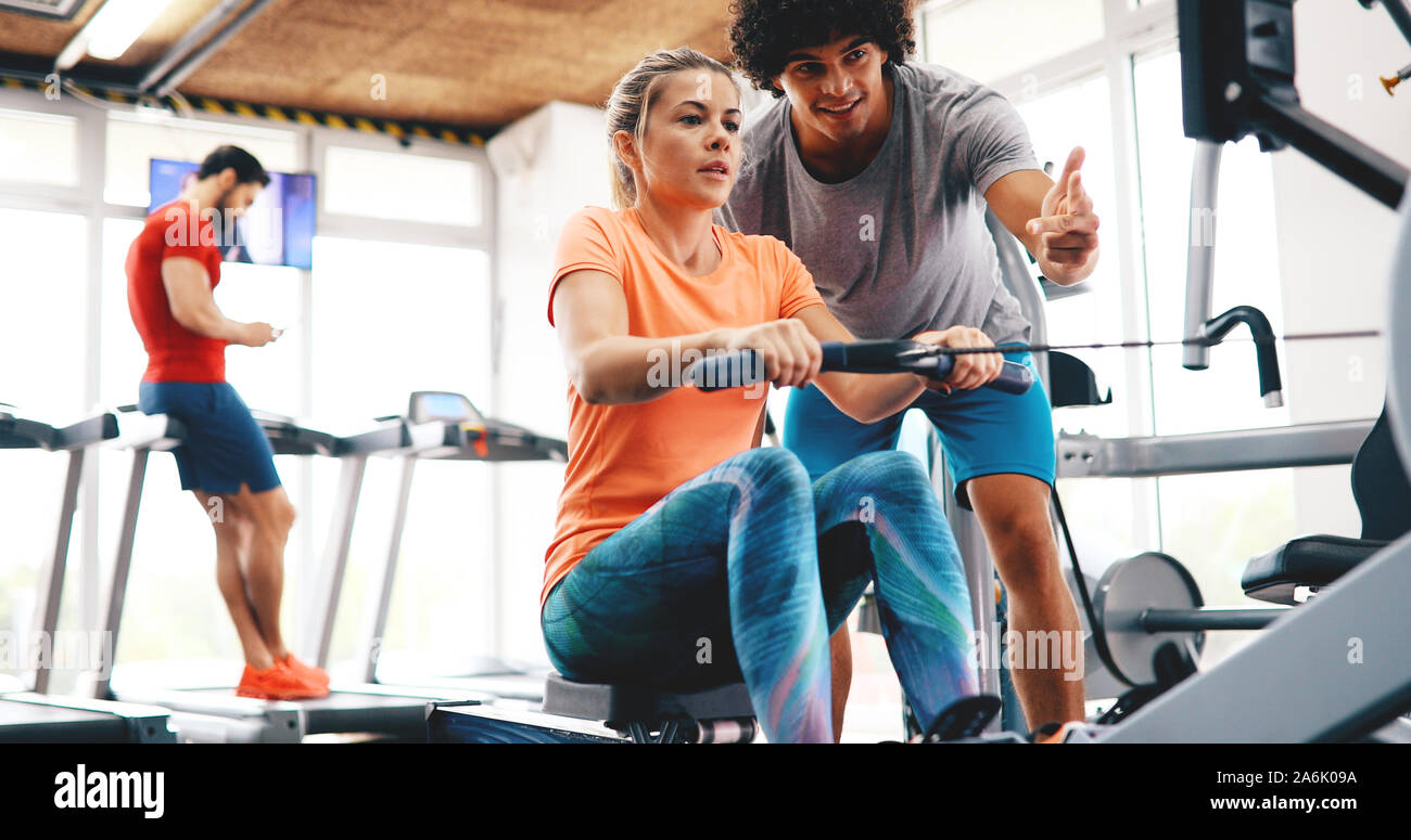 Young beautiful woman doing exercises with personal trainer Stock Photo