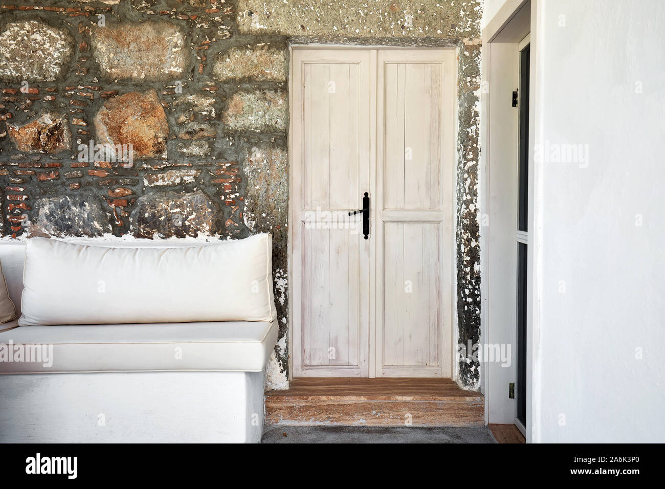 White wooden door and the entrance patio of a historical Mediterranean stone house Stock Photo