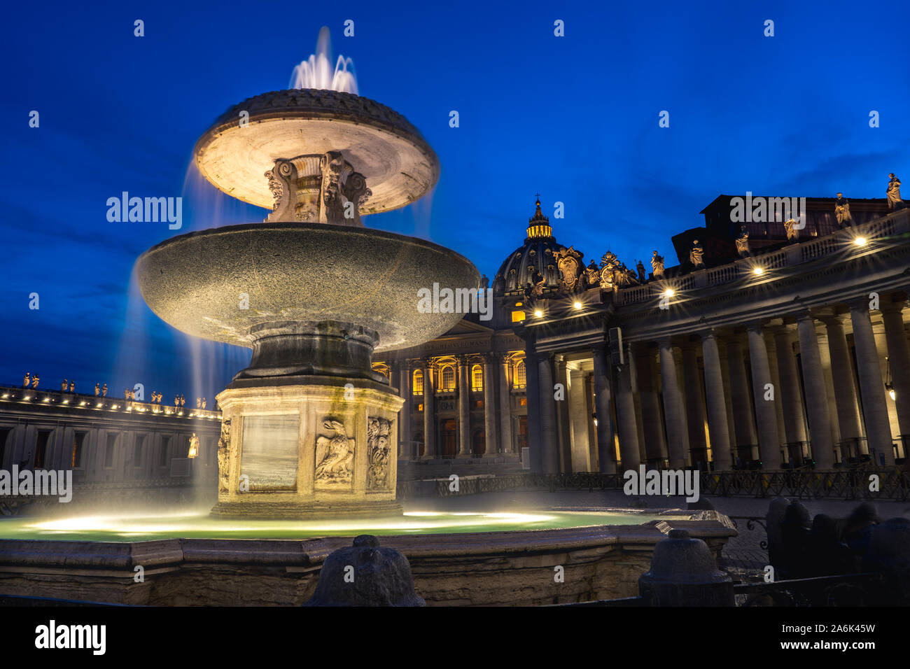Night picture of Maderno's fountain and St. Peter's Basilica at the background during blue hour. Long exposure photo of Maderno's fountain in Vatican Stock Photo