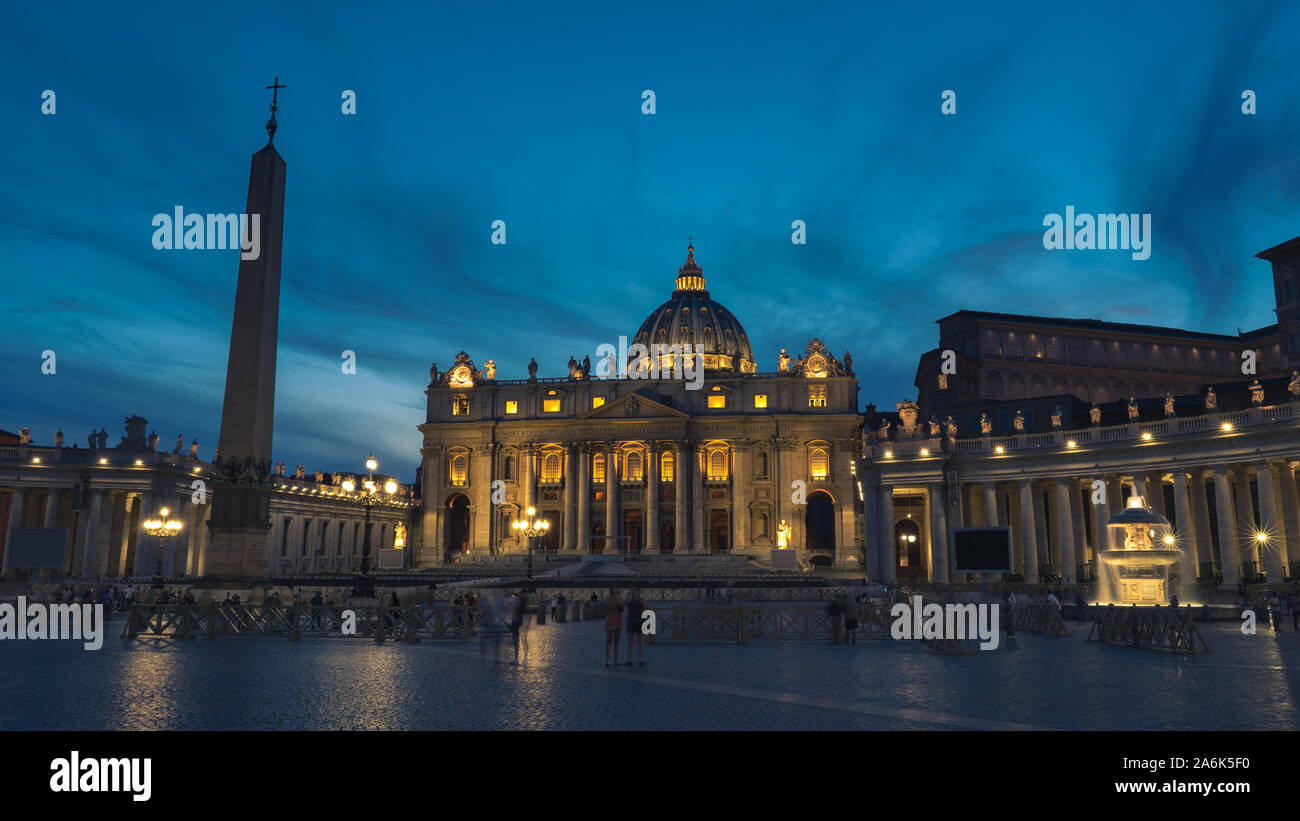 A night picture of The Papal Basilica of St. Peter in the Vatican. St Peter's, Bernini's colonnade and Maderno's fountain at night during blue hour. Stock Photo