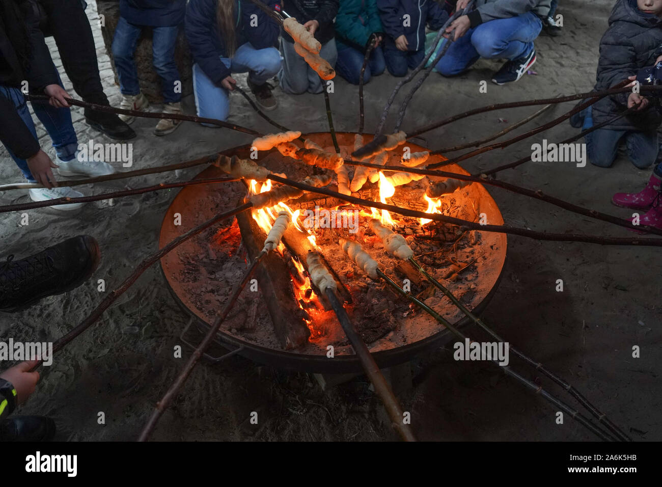 Berlin, Germany. 27th Oct, 2019. Numerous stick breads are held over the fire at the autumn festival in the children's farm Pinke-Panke. Credit: Jörg Carstensen/dpa/Alamy Live News Stock Photo