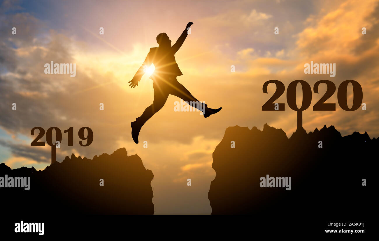 Business people are jumping across the abyss from 2019 to 2020 Stock Photo