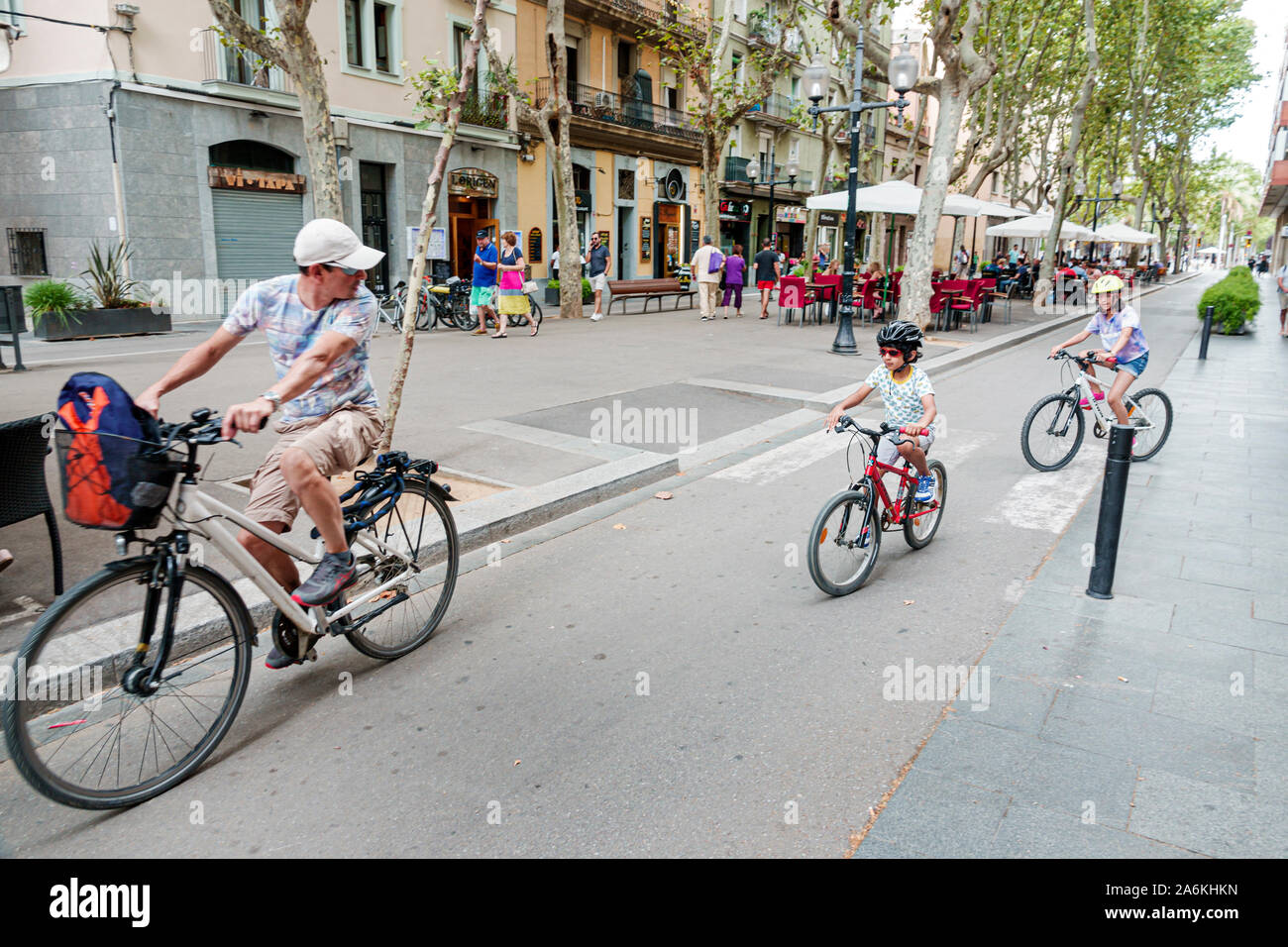 Barcelona Spain,Catalonia El Poblenou,Rambla del Poblenou,pedestrian promenade,man,boy,girl,father,son,family,riding bicycles,helmet,children,ES190820 Stock Photo
