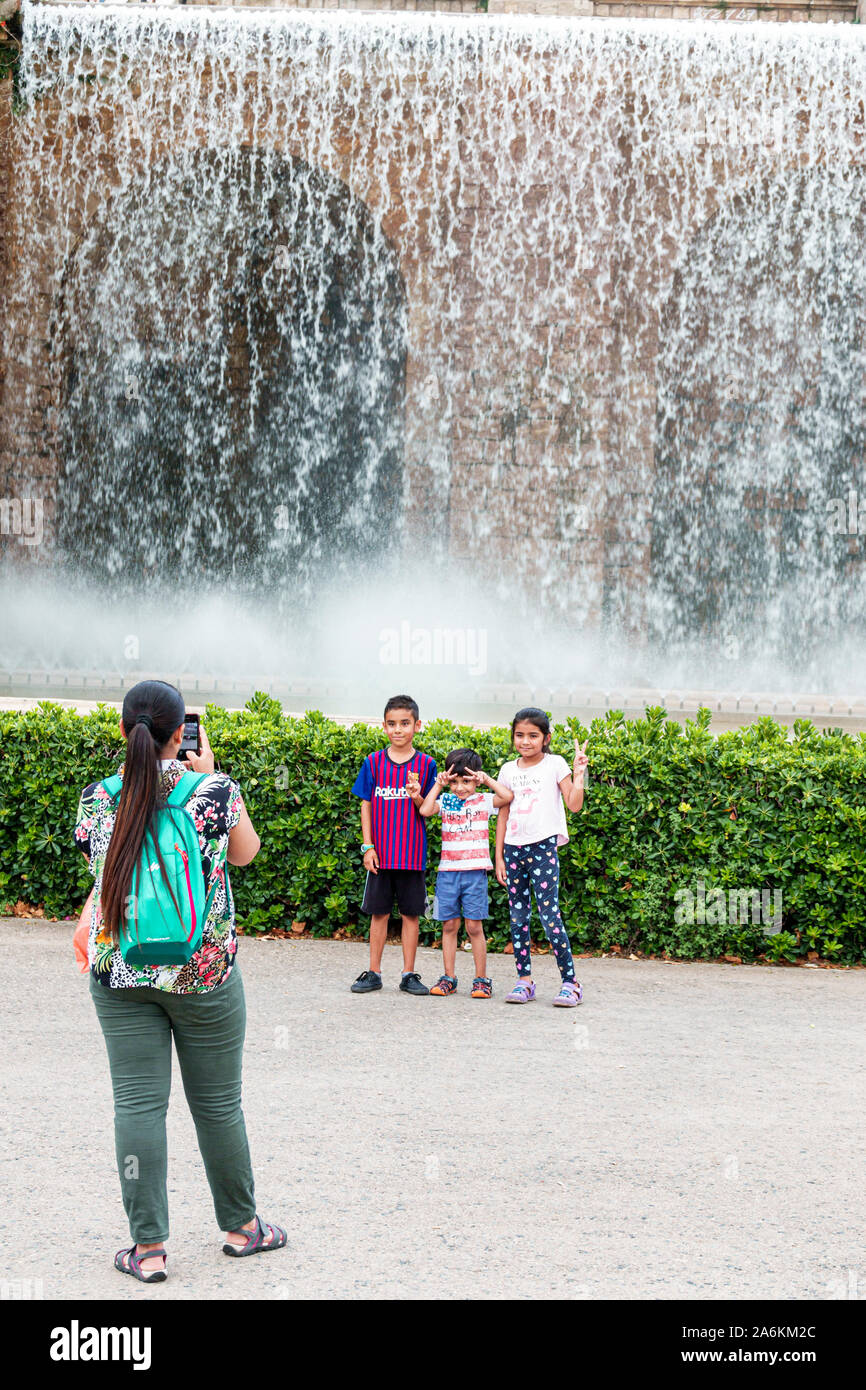 Barcelona Spain,Catalonia Parc de Montjuic,fountain,woman,mother,son daughter,boy,girl,family,taking photo,hand signs,Hispanic,ES190821170 Stock Photo