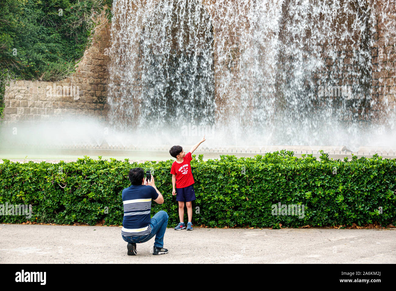 Barcelona Spain,Catalonia Parc de Montjuic,fountain,man,boy,pointing,father,son,family,taking photo,Hispanic,ES190821168 Stock Photo