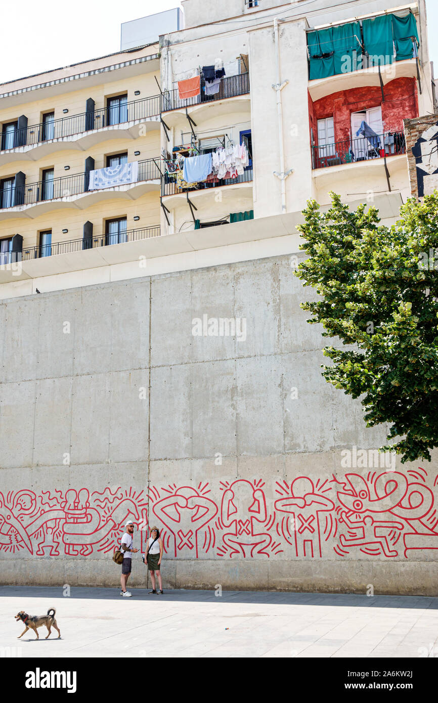 Barcelona Spain,Catalonia Ciutat Vella,El Raval,plaça de Salvador Segui,Keith Haring,mural,replica,AIDS awareness,1989,public art,man,woman,couple,dog Stock Photo