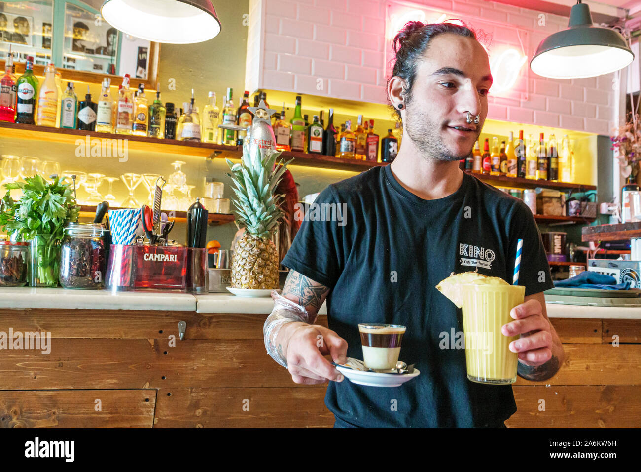 Barcelona Spain,Catalonia Ciutat Vella,El Raval,Kino Cafe, restaurant,bar,dining,man,waiter server,carrying drinks,coffee,smoothie,nose piercing,nostri Stock Photo