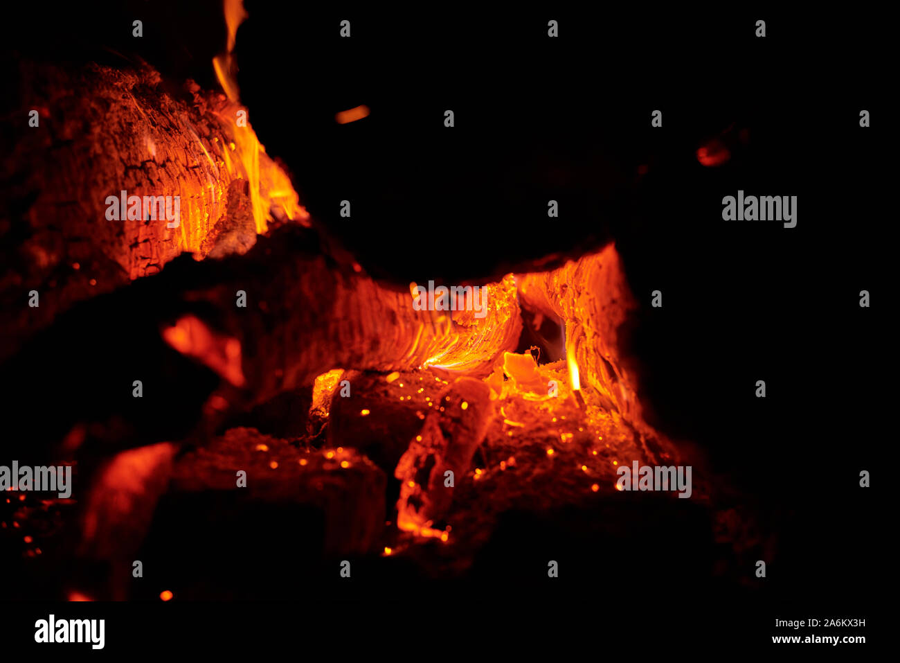 Close up of bonfire with sparks at night. Heat from burning logs and ...
