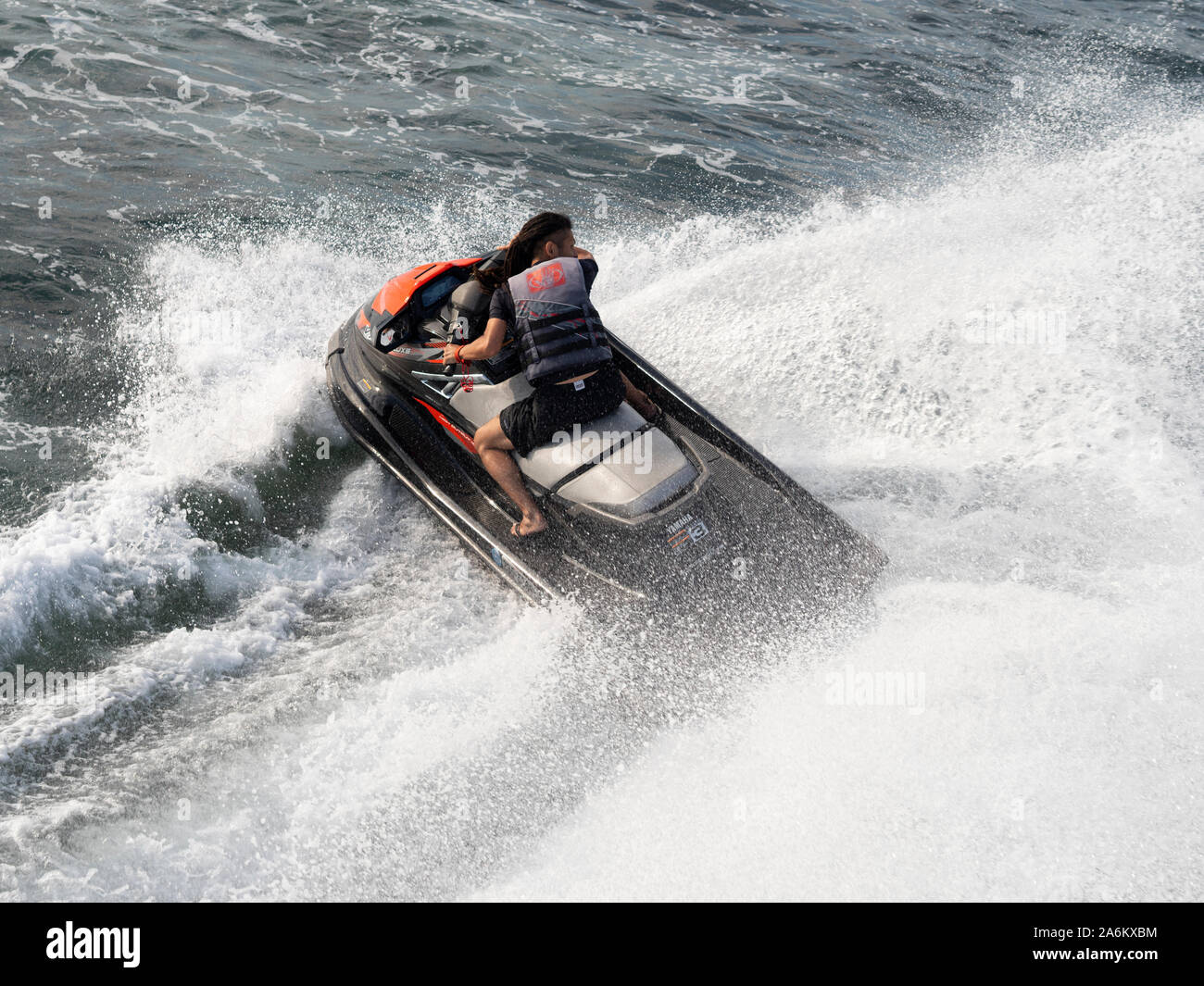 Man makes sharp turns with jet ski to splash water up to the bridge