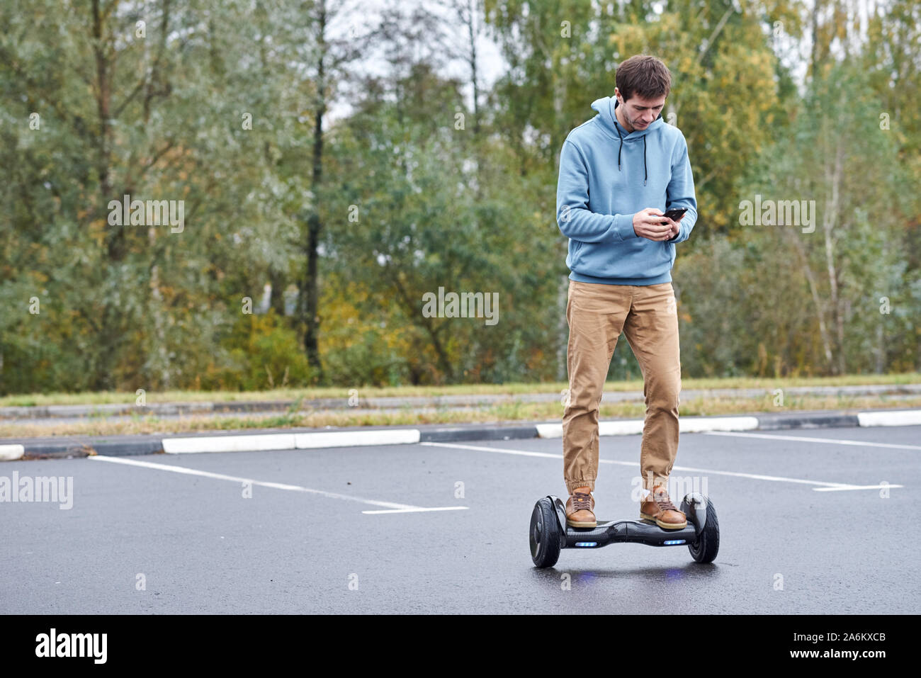 Man riding on hoverboard and using smartphone outdoor Stock Photo - Alamy