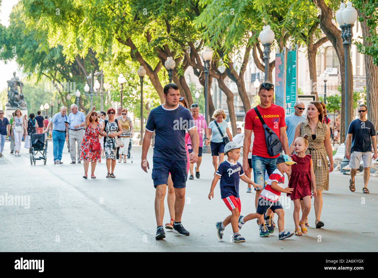 Tarragona Spain Hispanic Catalonia Rambla Nova,pedestrian pedestrians promenade,tree lined park,pedestrians,family,man,woman,boy,girl,family,strolling Stock Photo