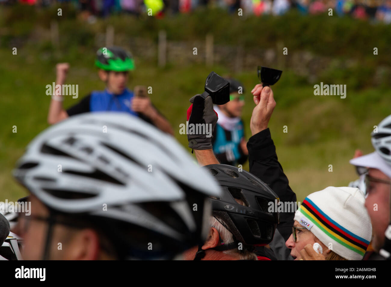 Enthusiastic spectators ring cowbells and thump the air as for the 2019 UCI Road World Championships, UK Stock Photo