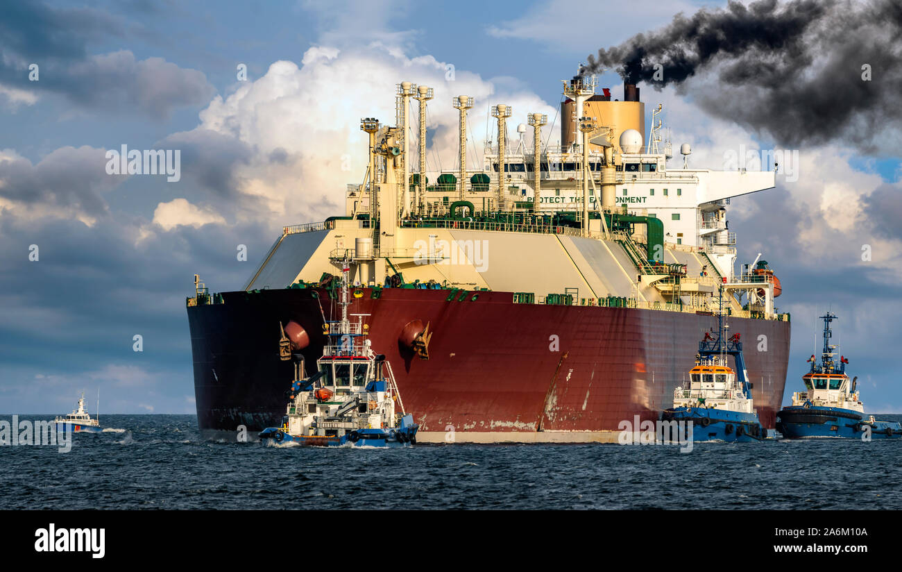 Lng tanker assisted by tug boats entering the port Stock Photo