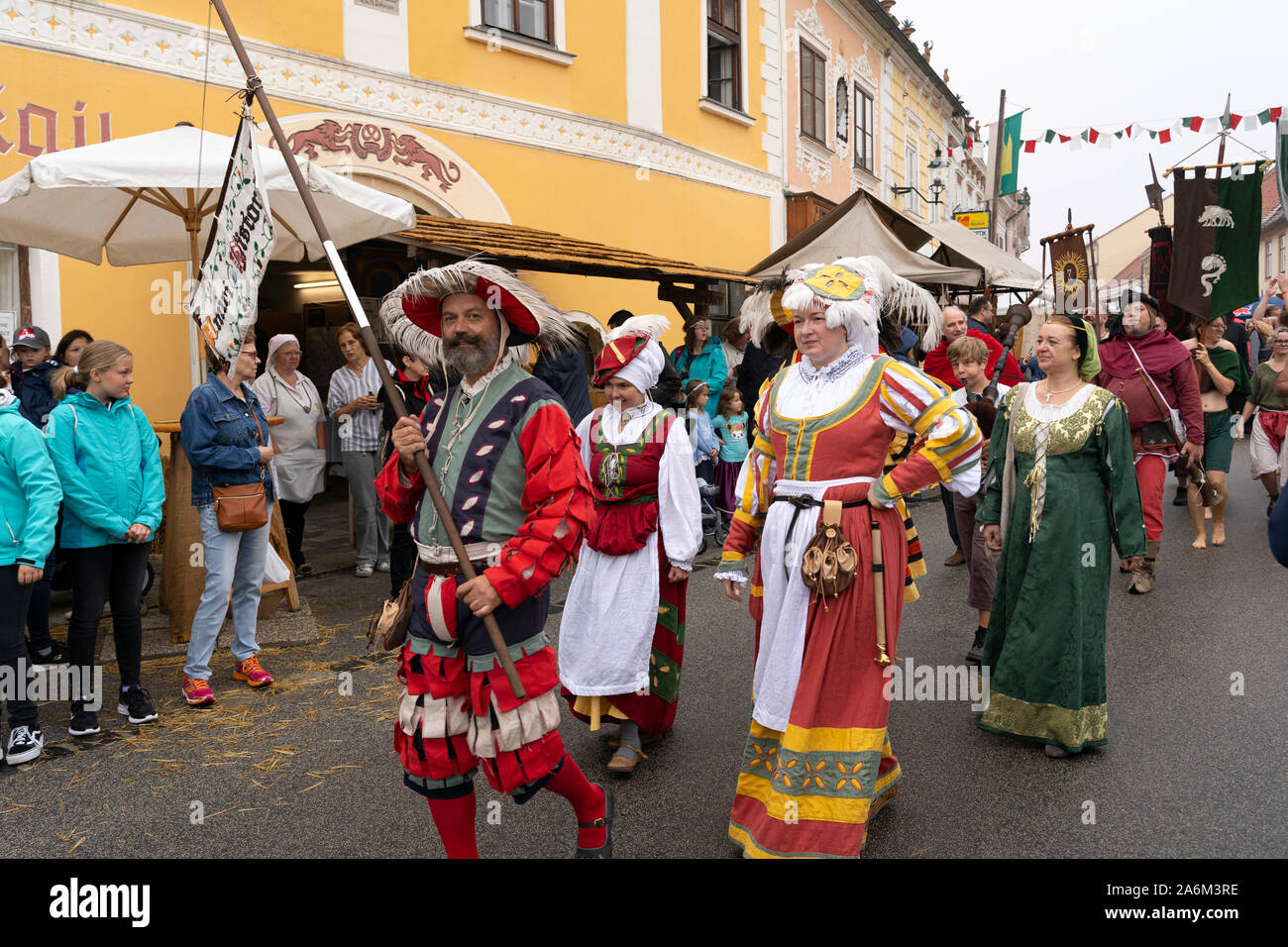Historic actors wearing colourful medieval clothes and carrying banners in a parade, Eggenburg Medieval Festival, Austria's largest medieval event Stock Photo