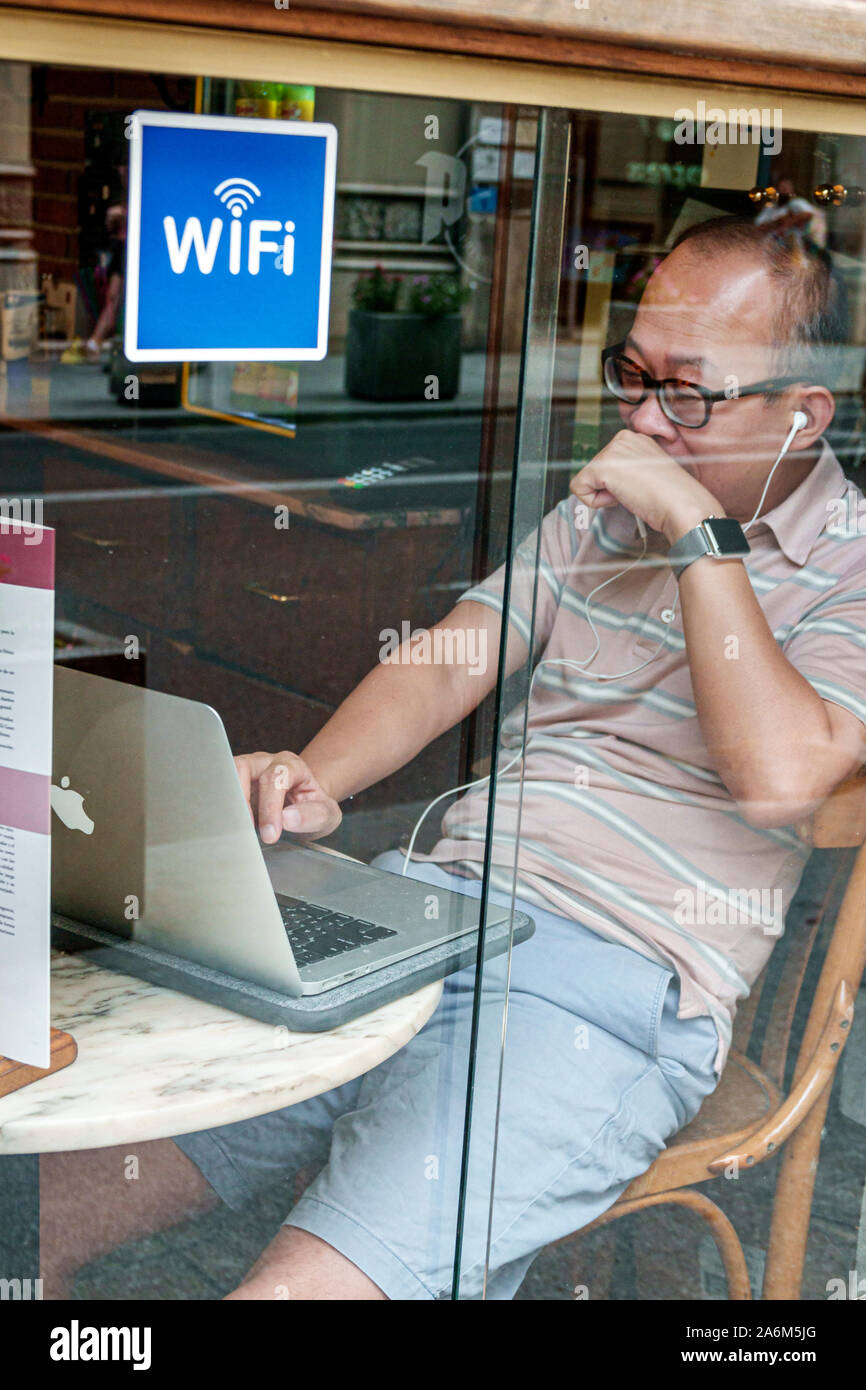 Valencia Spain,Ciutat Vella,old city,historic center,Calle de la Paz,cafe,wifi,Asian,man,using laptop,view through window,ES190829139 Stock Photo