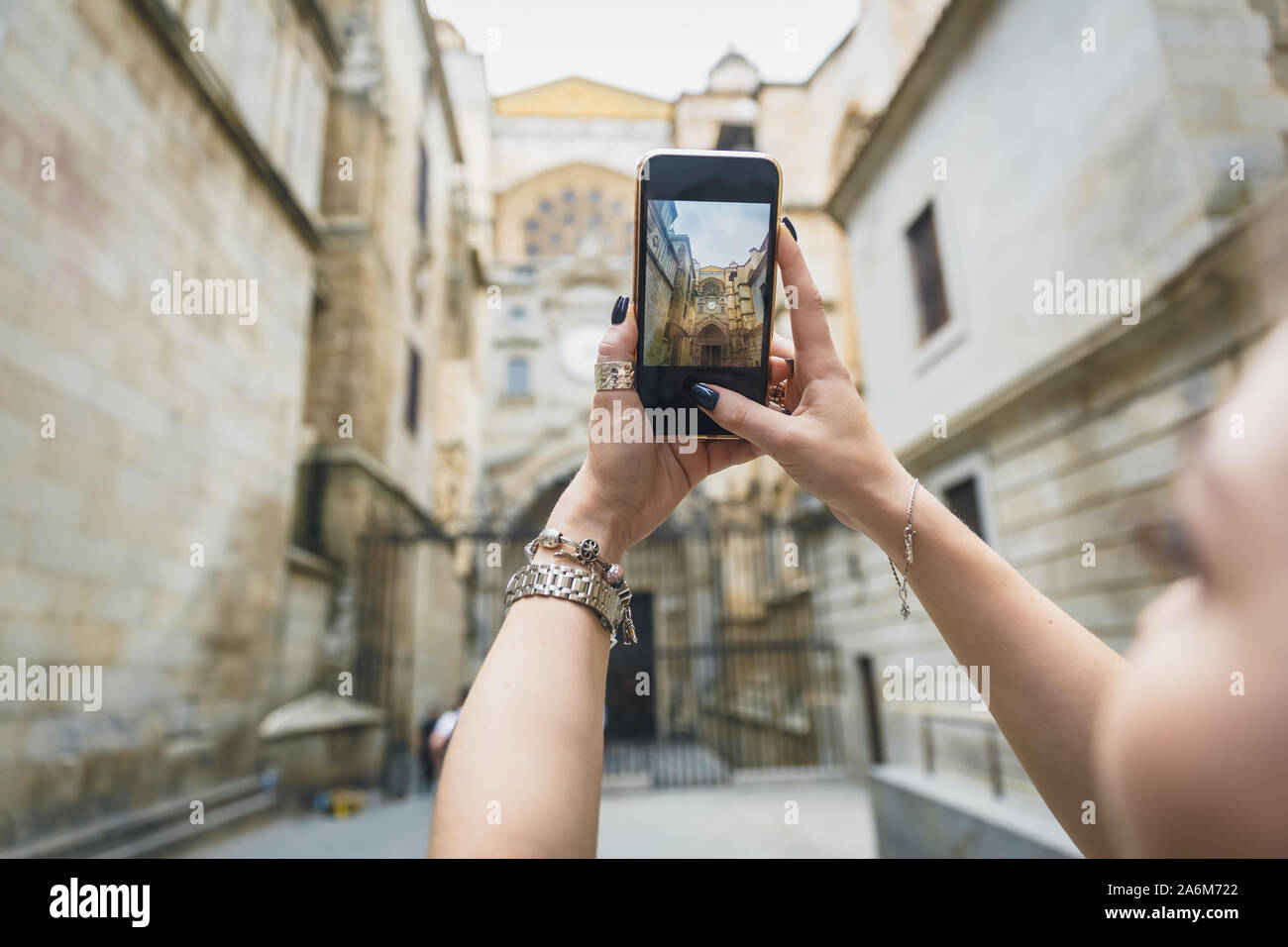 Girl makes a photo or video on the phone. Hands hold a smartphone and make a photo with landmark in the europe old town Stock Photo