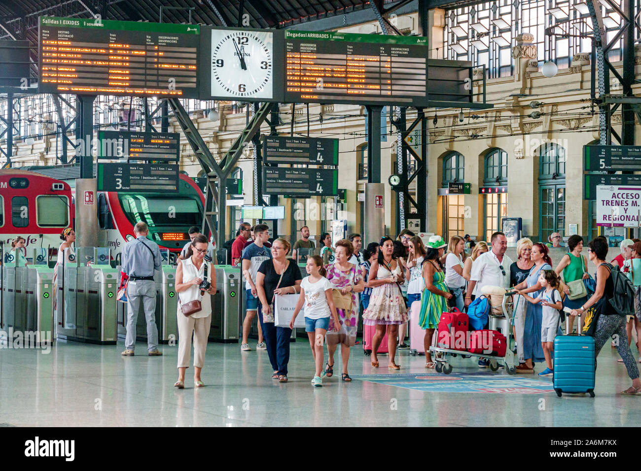 Valencia Spain,Estacio del Nord,Renfe train railway station,inside interior,platform,digital departure board,clock,turnstiles,passengers commuters,lug Stock Photo