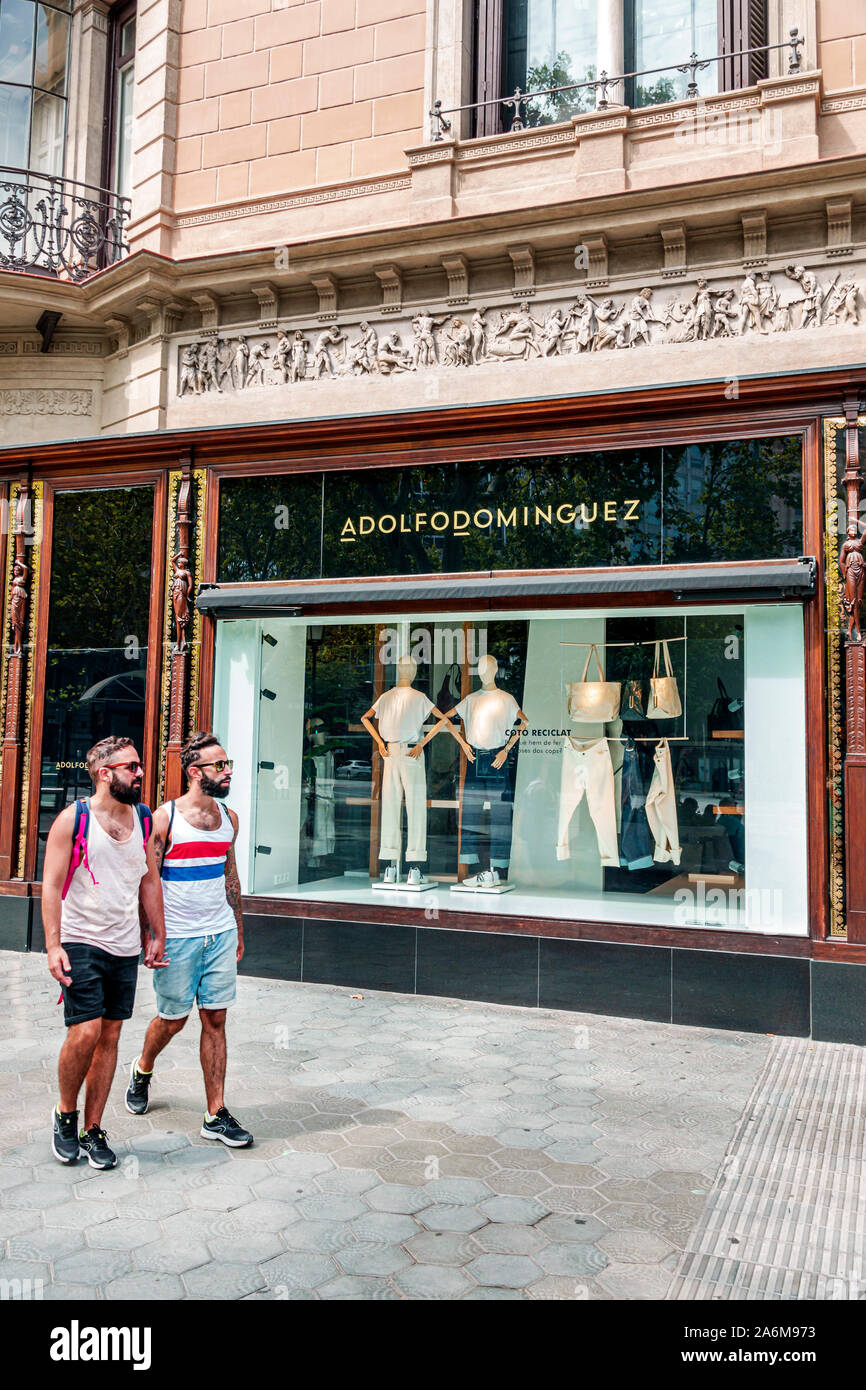 Barcelona Spain,Catalonia Passeig de Gracia,shopping district,Adolfo Dominguez,designer boutique,storefront,window display,man,couple,gay,LGBT,holding Stock Photo