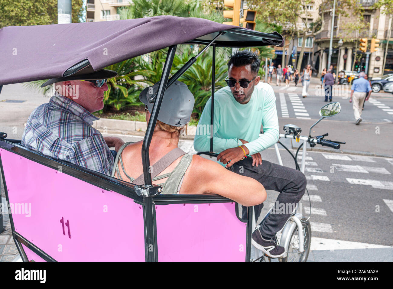 Barcelona Spain,Catalonia Eixample,Plaza de Mosen Jacinto Verdaguer,Avinguda Diagonal,pedicab,bicycle rickshaw,passengers,driver,man,woman,couple,ES19 Stock Photo
