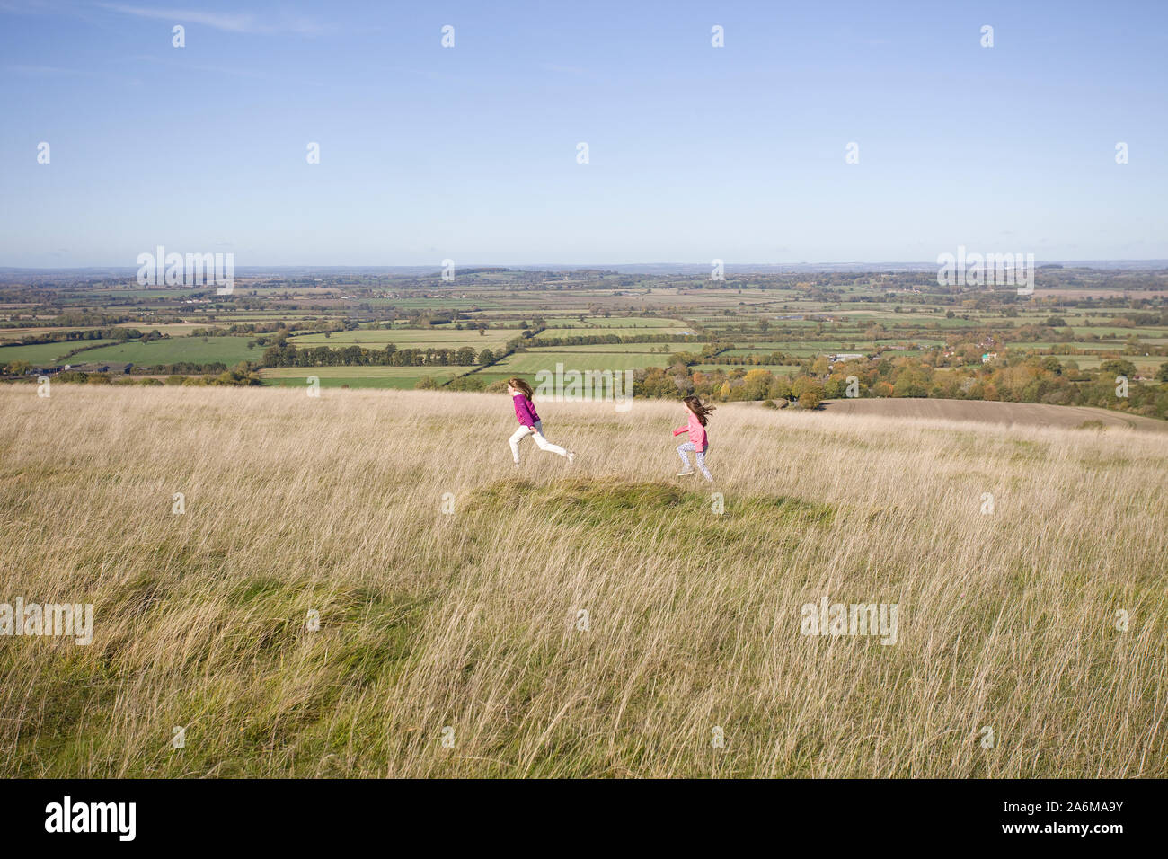 Kids running around fields at White Horse Hill, Uffington, Oxfordshire Stock Photo