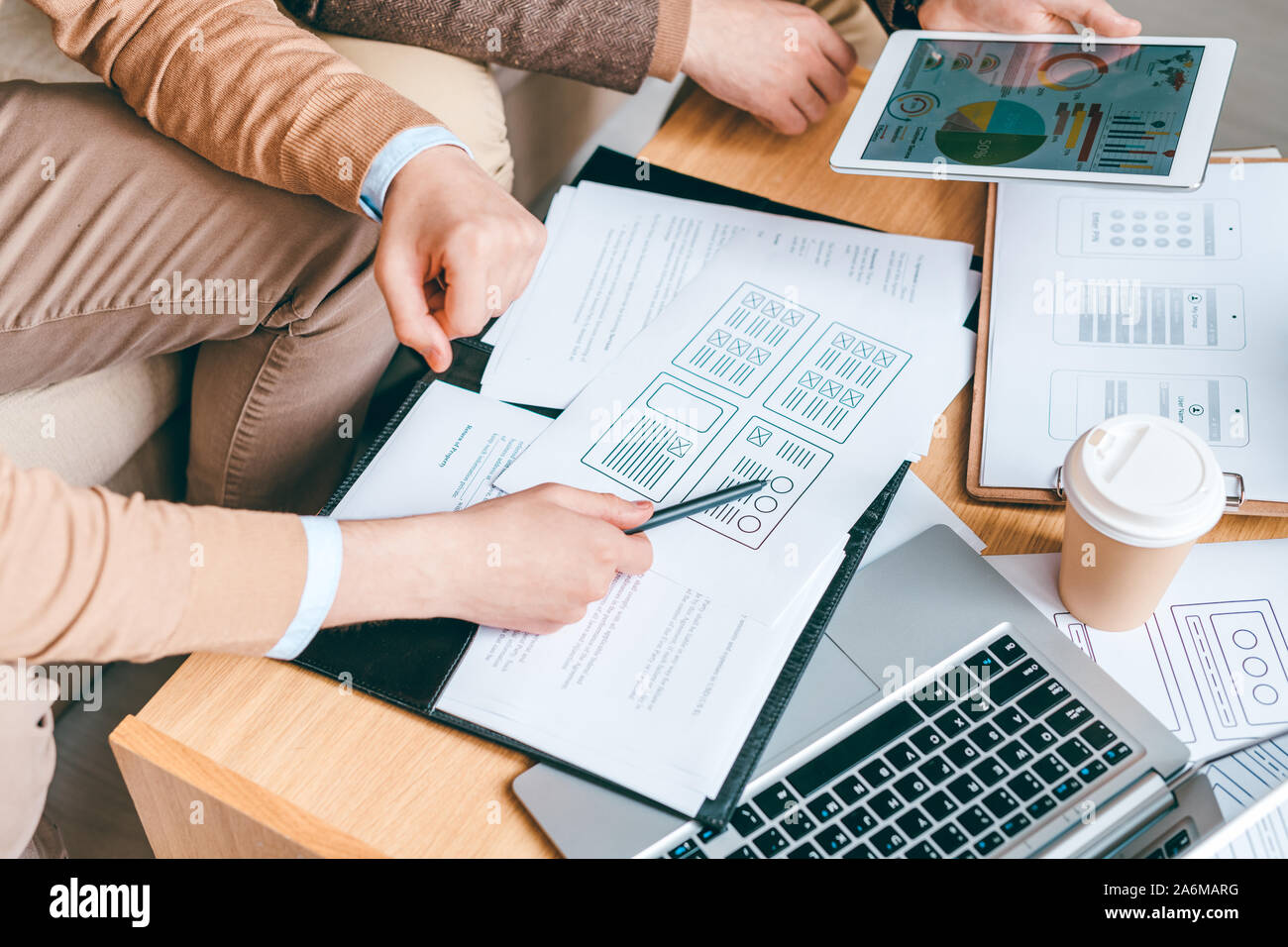 Young software or program developer with pen pointing at one of papers Stock Photo