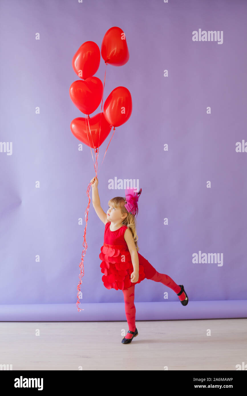 Beautiful little girl holding red balloons hollidays Stock Photo Alamy