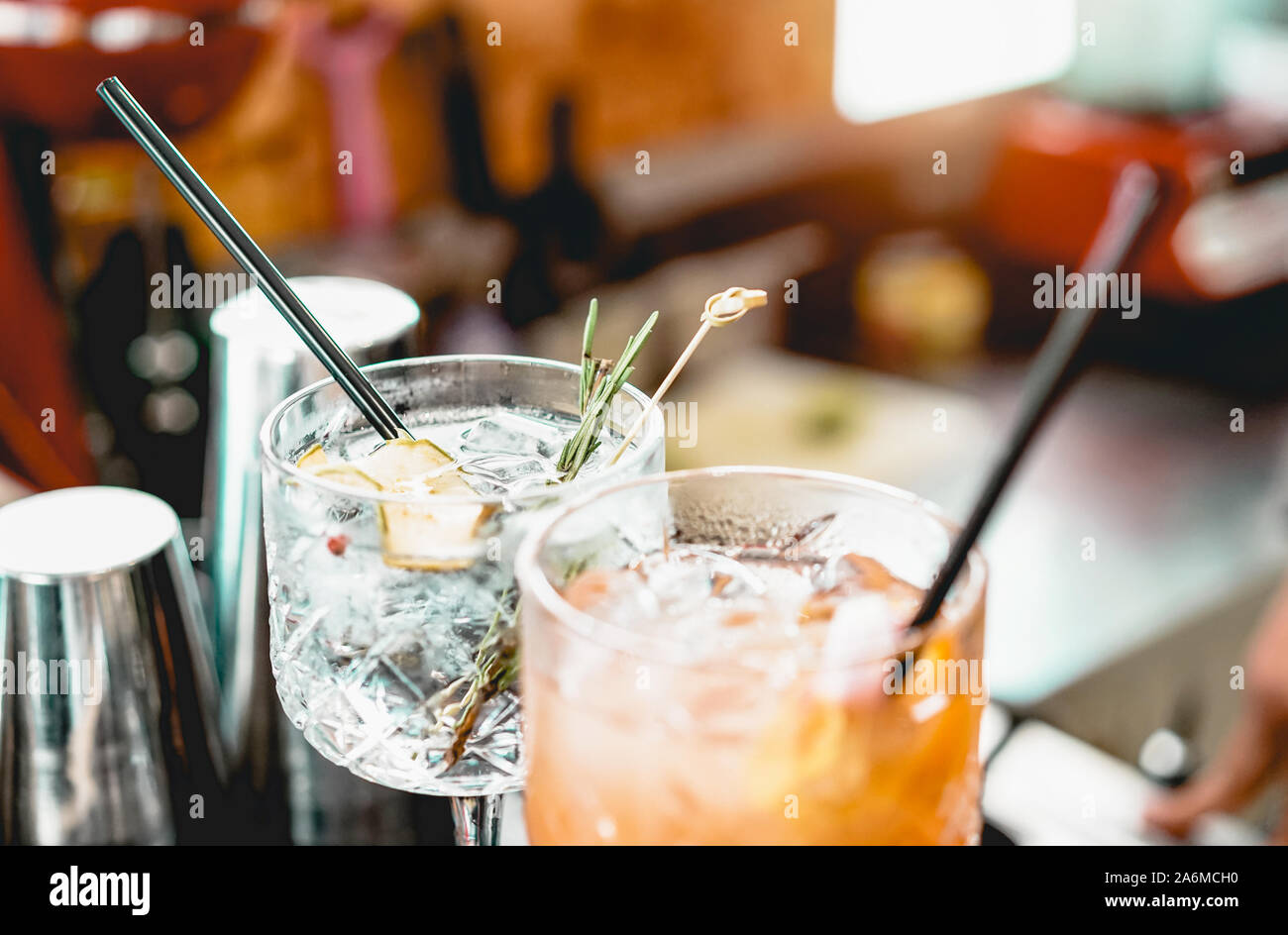 Cocktails served on bar counter prepared with gin, rosemary, paper and