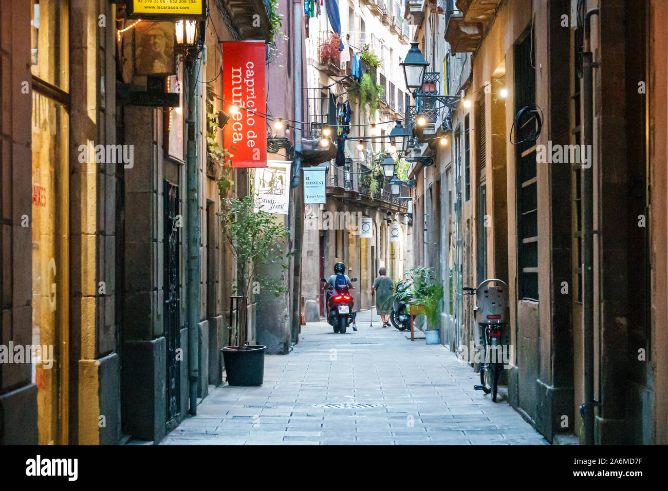 Barcelona Spain,Catalonia Ciutat Vella,historic center,El Born,Carrer del Brosoli,narrow street,shop signs,woman,man,motorcycle,ES190903169 Stock Photo
