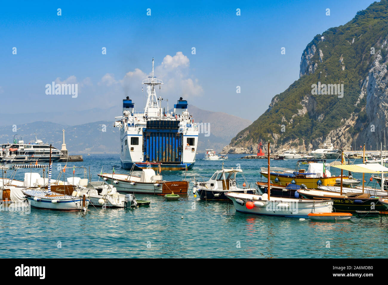 ISLE OF CAPRI, ITALY - AUGUST 2019: Large car and passenger ferry departing harbour on the Isle of Capri. Stock Photo