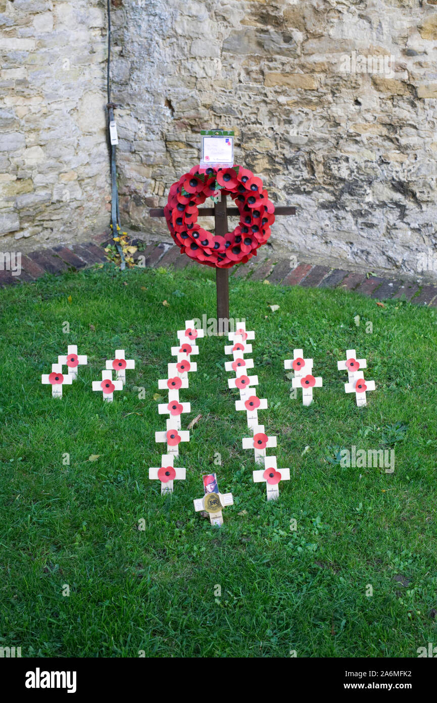 Remembrance Day Poppy Wreath and crosses in a town churchyard. Stock Photo