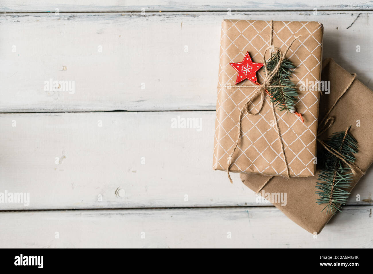 Stack of two wrapped giftboxes bound with threads on white table Stock Photo