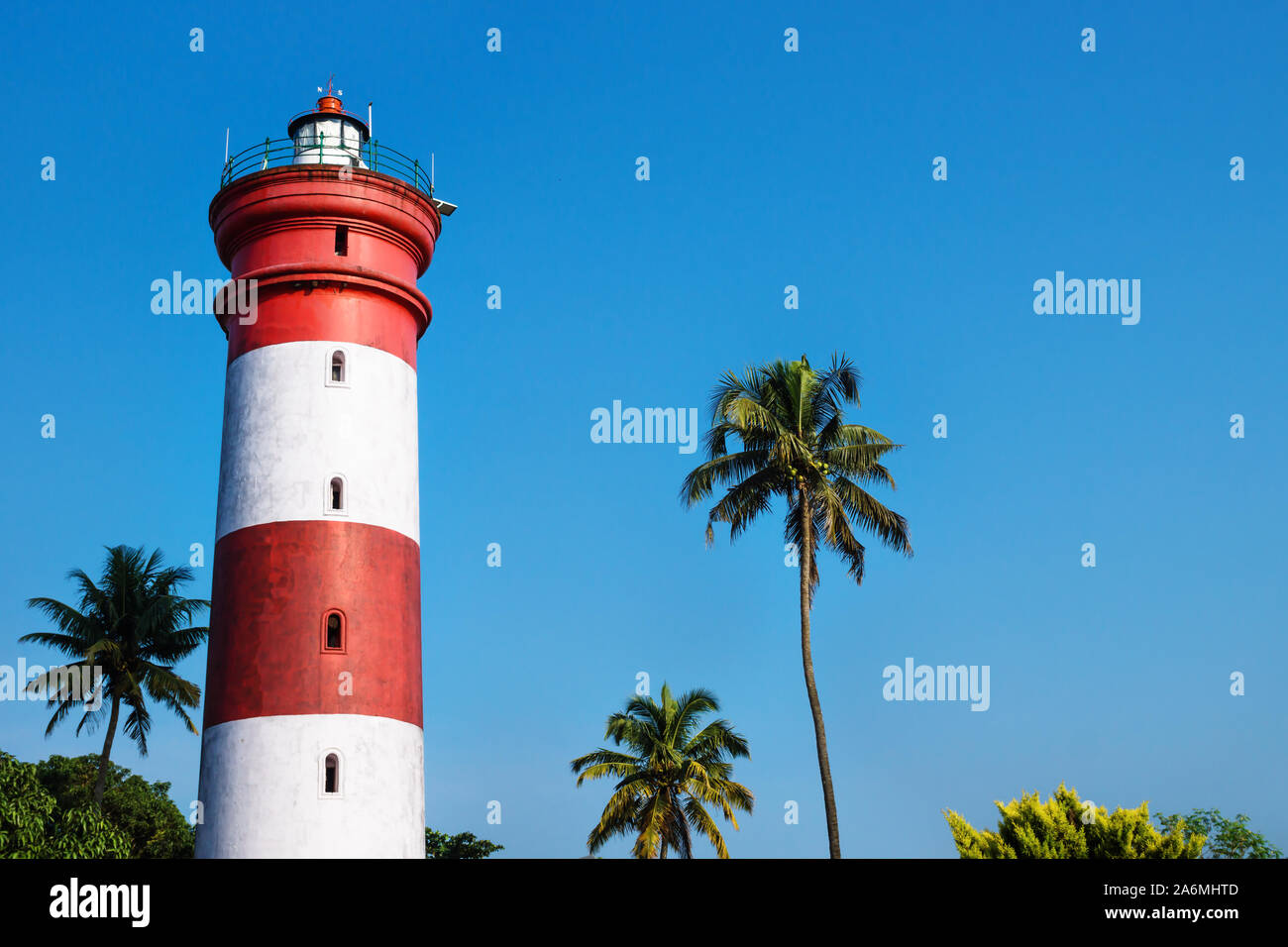Alleppey Lighthouse with red and white stripes with palm trees on