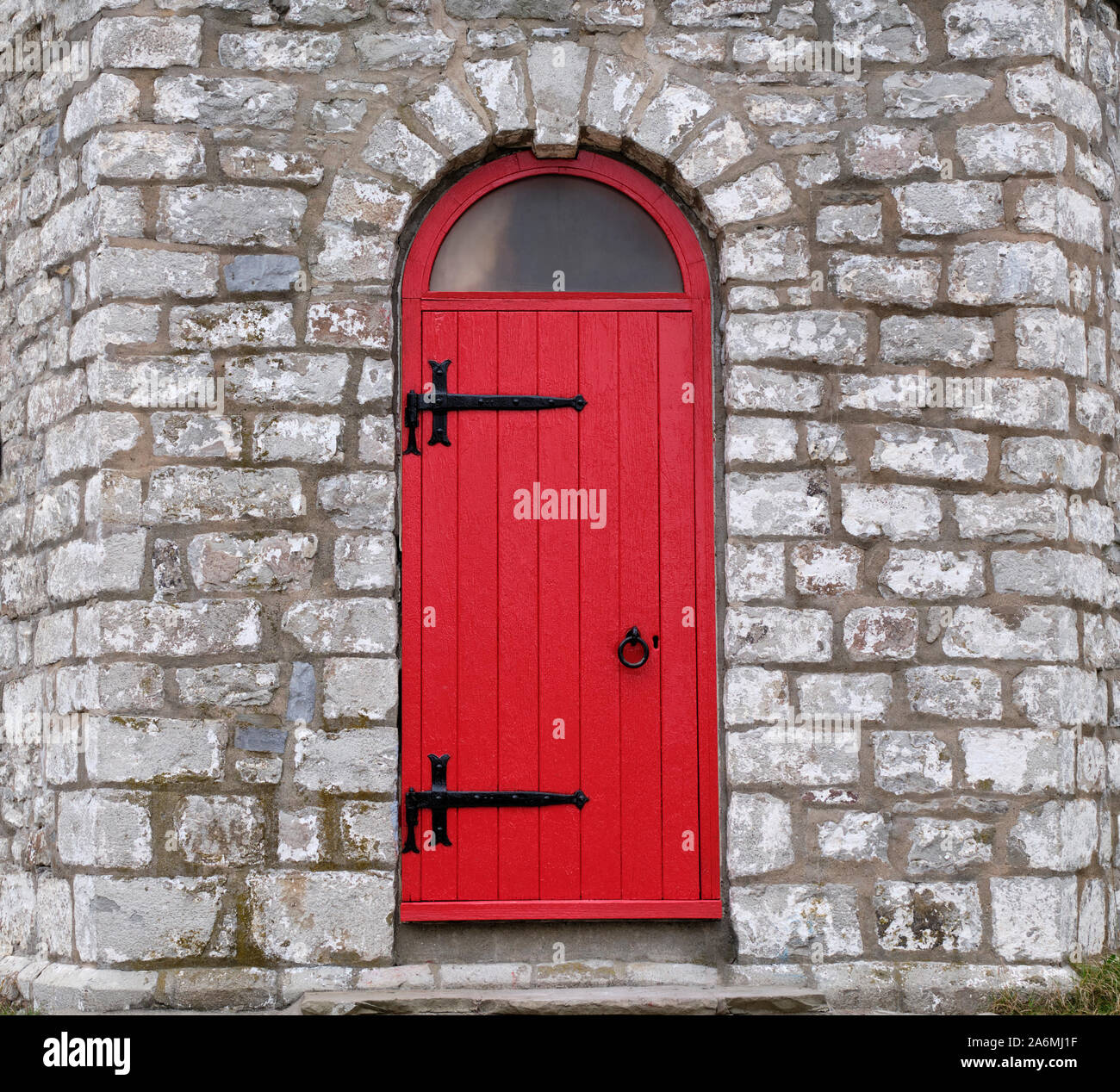The bright red door with black iron hardware is the entrance to the old