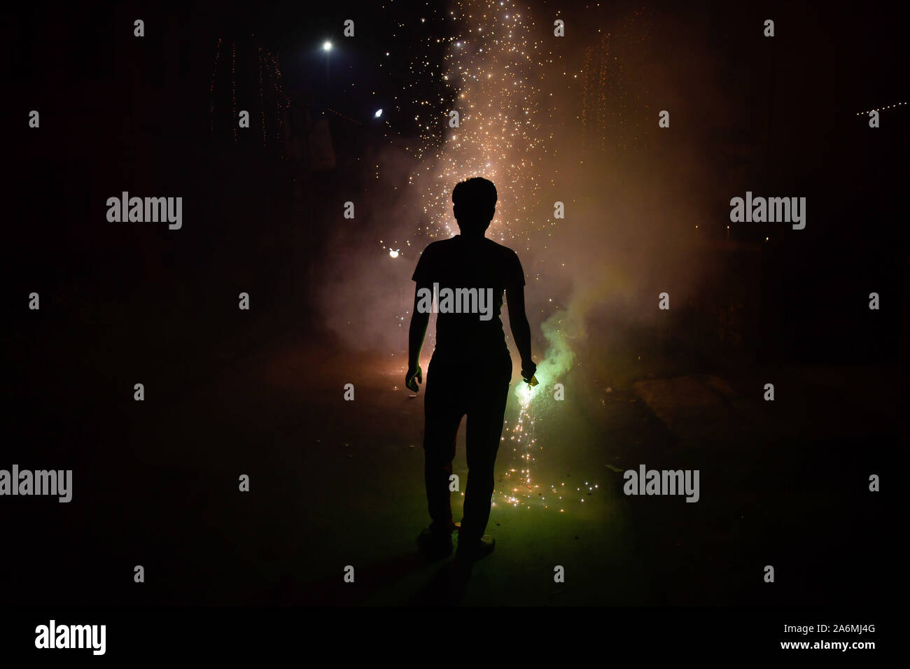 Kolkata, India. 27th Oct, 2019. A man burning firecrackers enjoys the sparkles, light and sound on Diwali in Kolkata.Diwali is known as the ''festival of lights''. It marks victory of good over evil and light over darkness. Diwali celebration has also created a persistent pollution problem for burning firecrackers in India for years. Credit: Avijit Ghosh/SOPA Images/ZUMA Wire/Alamy Live News Stock Photo